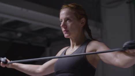 fotografía de estudio de una mujer madura con ropa de gimnasia haciendo ejercicio con banda de resistencia 2