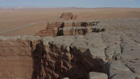 Drone-shot-flying-over-bizarre-sandstone-rock-canyon-walls-near-a-road-in-sunny-southern-Utah