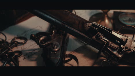 an someone puts and old pistol on the table filled with documents and maps inside the sailing ship cabin
