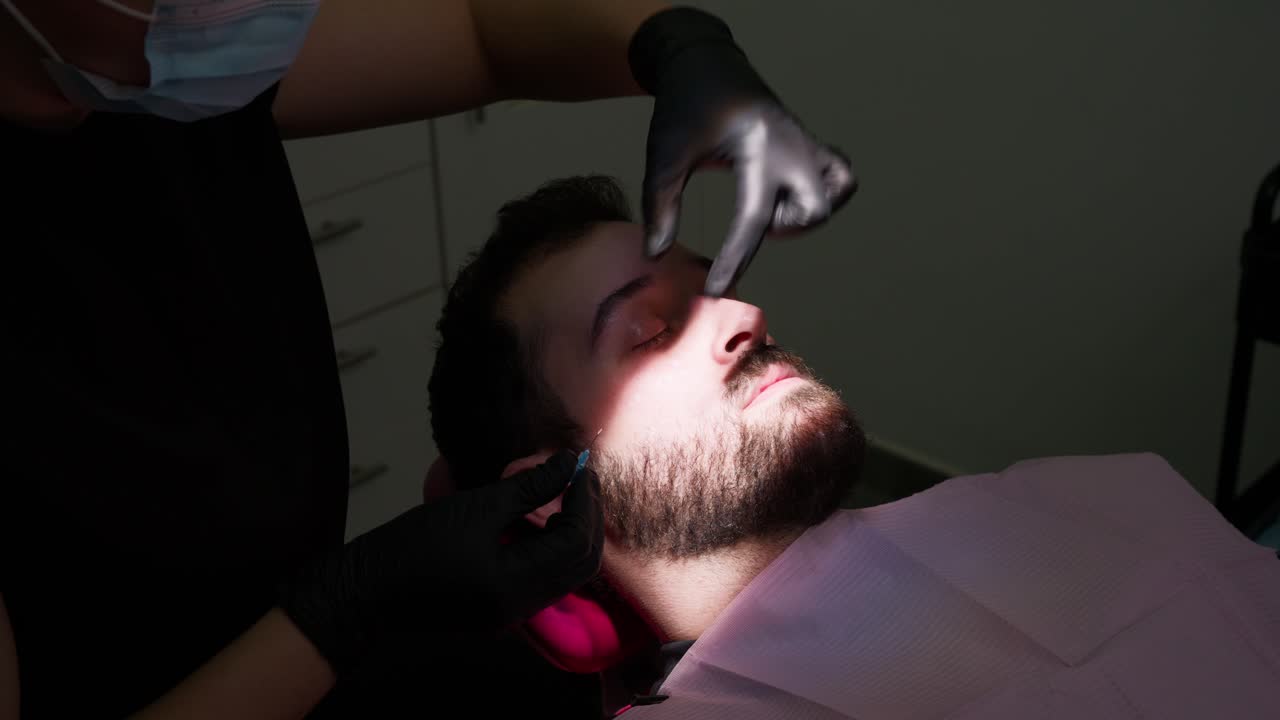 Medico che somministra un'iniezione a un paziente uomo in una clinica medica