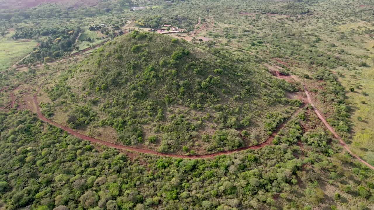 아프리카 농장 한가운데 있는 언덕 위로 드론이 날아가는 모습