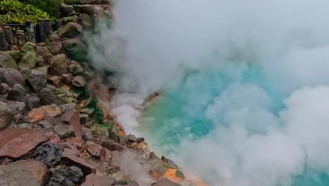 umi jigoku or sea hell taken in beppu with steamy hot springs geyser steaming off the cobalt water