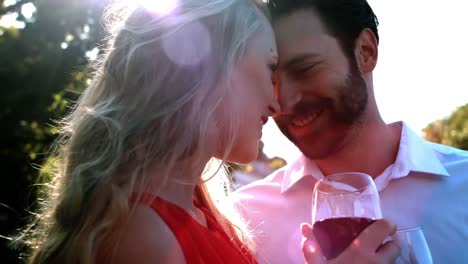 smiling romantic couple toasting wine glasses