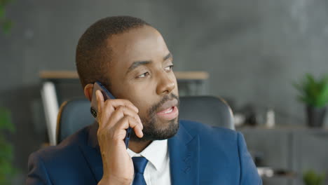 american businessman talking on smartphone in the office