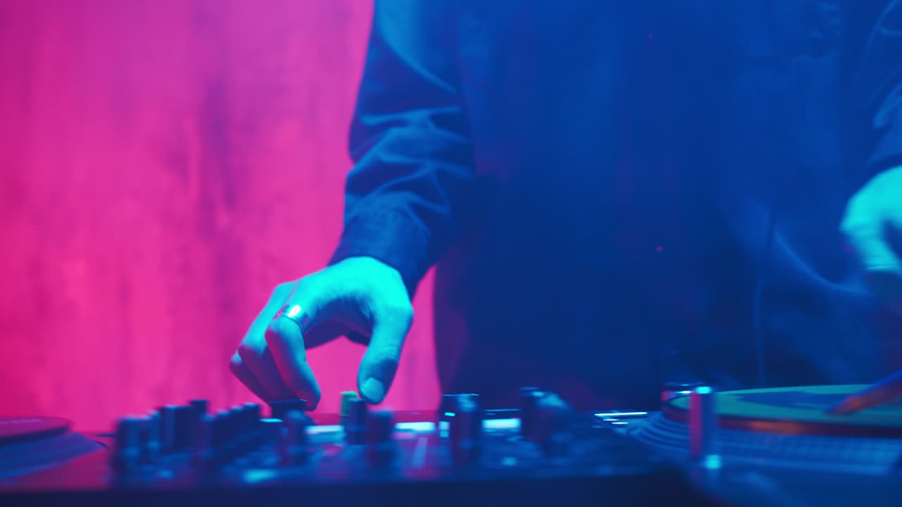 un dj moderno de apariencia asiática realiza una pista de música con iluminación de neón.