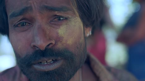 indian man close-up of face smeared with bright holi colors