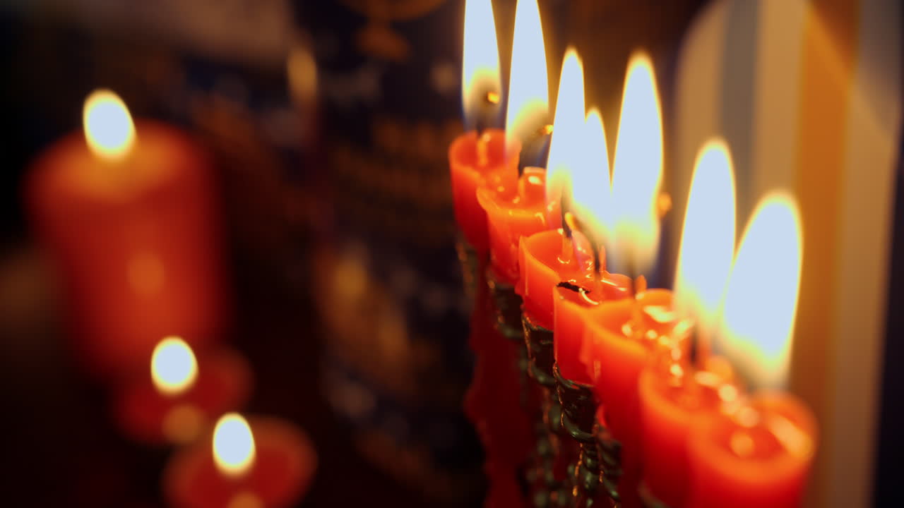 Primo piano di candele rosse accese su una menorah per Hanukkah