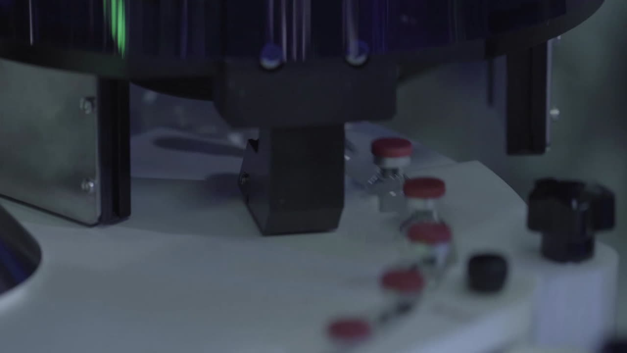 una gran cantidad de frascos de vidrio vacíos frascos con tapas rosas para drogas se mueven a lo largo de la línea de procesamiento en una fábrica