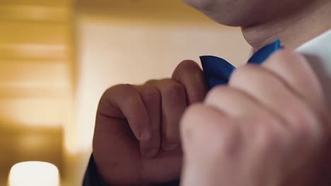 young guy adjusts his bow tie is preparing for the holiday