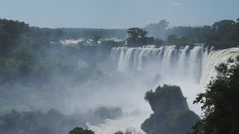 Iguazu-Falls-Waterfall-in-Argentina,-Dramatic-Distant-View-of-Waterfalls-in-Picturesque-Jungle-Greenery-Landscape,-Amazing-Splash-From-Water-Falling-off-Huge-Cliffs-in-Beautiful-Sunny-Conditions