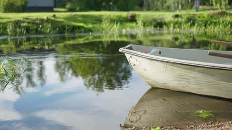 Un-Bote-De-Remos-En-Un-Río-Tranquilo-Con-Agua-Moviéndose-Lentamente-En-Un-Día-Soleado-De-Verano