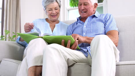 Senior-couple-looking-at-their-photo-album