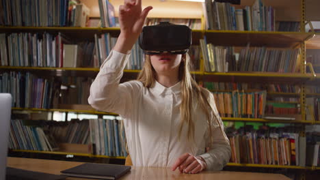 Niña-Adolescente-Usando-Auriculares-Vr-Mientras-Está-Sentada-En-La-Biblioteca-De-La-Escuela,-Toma-Manual