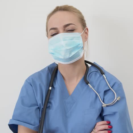 female nurse or doctor  young pretty woman in blue clothes with medical mask posing