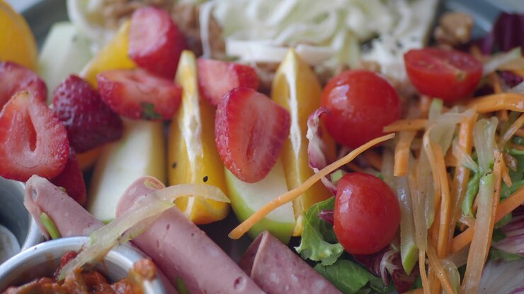 Close-up of a Colorful Breakfast Platter with Fresh Fruits, Vegetables, and Deli Meats