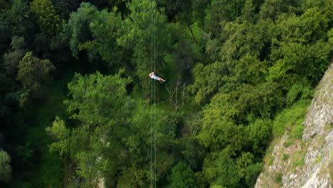 Hombre-Tirolesa-Extendiendo-Los-Brazos-Y-Disfrutando-De-Una-Emocionante-Aventura-En-La-Cueva-De-Pazin,-Istria,-Croacia