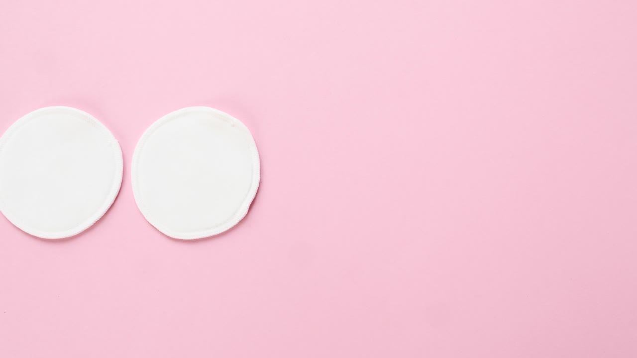 las mujeres jóvenes ponen almohadillas de algodón orgánico sobre un fondo rosa. cero residuos, reutilizables, ecológicos, removedores de maquillaje y concepto de lavado. patrón, luz dura, vista superior.
