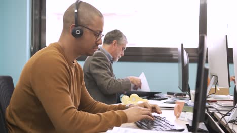 multiethnic colleagues working on computers in office workspace
