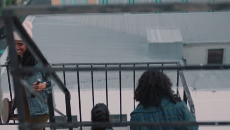 group-of-young-multiracial-friends-walking-up-fire-escape-stairs-ready-for-rooftop-party-chatting-sharing-excitement-for-weekend-celebration