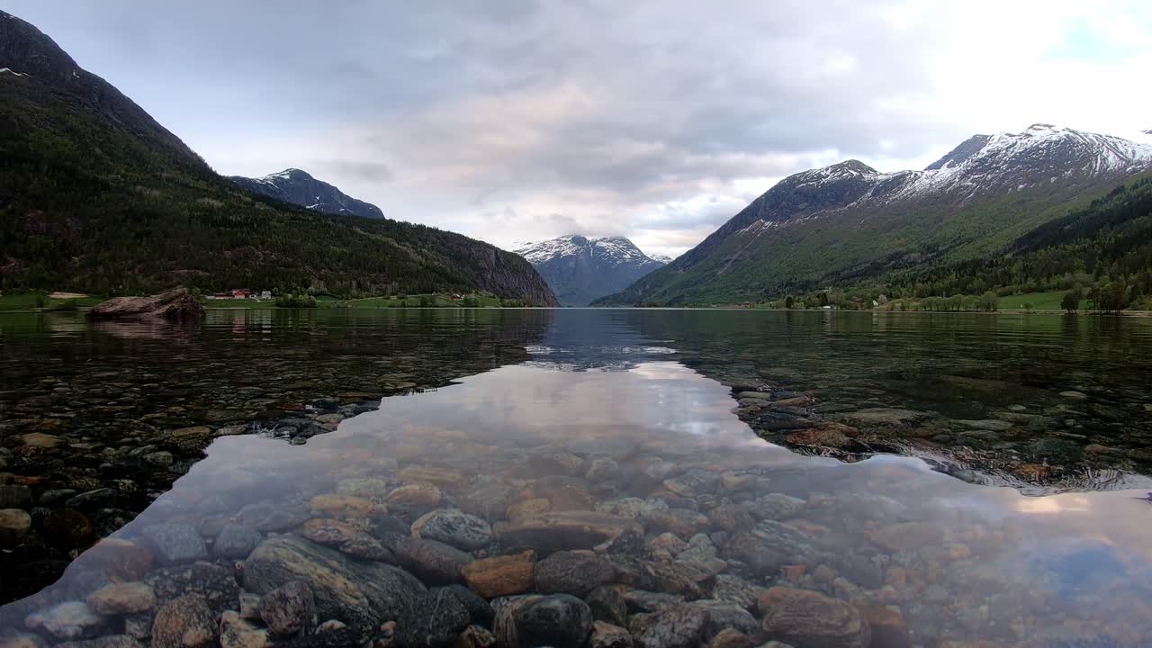 Oppstrynsvatnet lake in Stryn Nordfjord - Time lapse close to water surface with passing clouds and rain incoming in end of clip