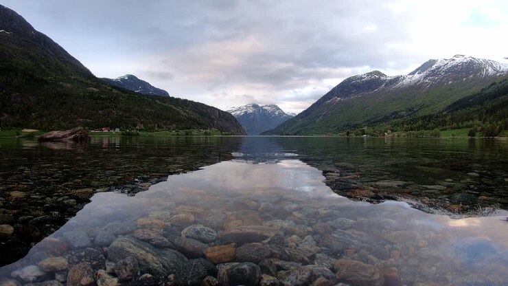 Oppstrynsvatnet lake in Stryn Nordfjord - Time lapse close to water surface with passing clouds and rain incoming in end of clip