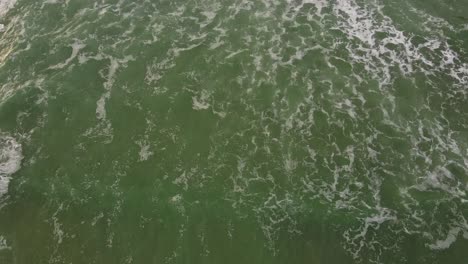 Cornwall-Polly-Joke-drone-tilt-shot-looking-down-at-seawaves-in-Cornish-coast,-UK