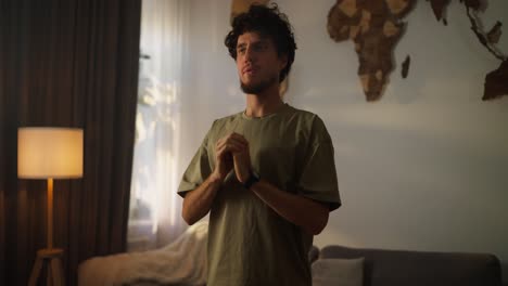 man praying in a home living room