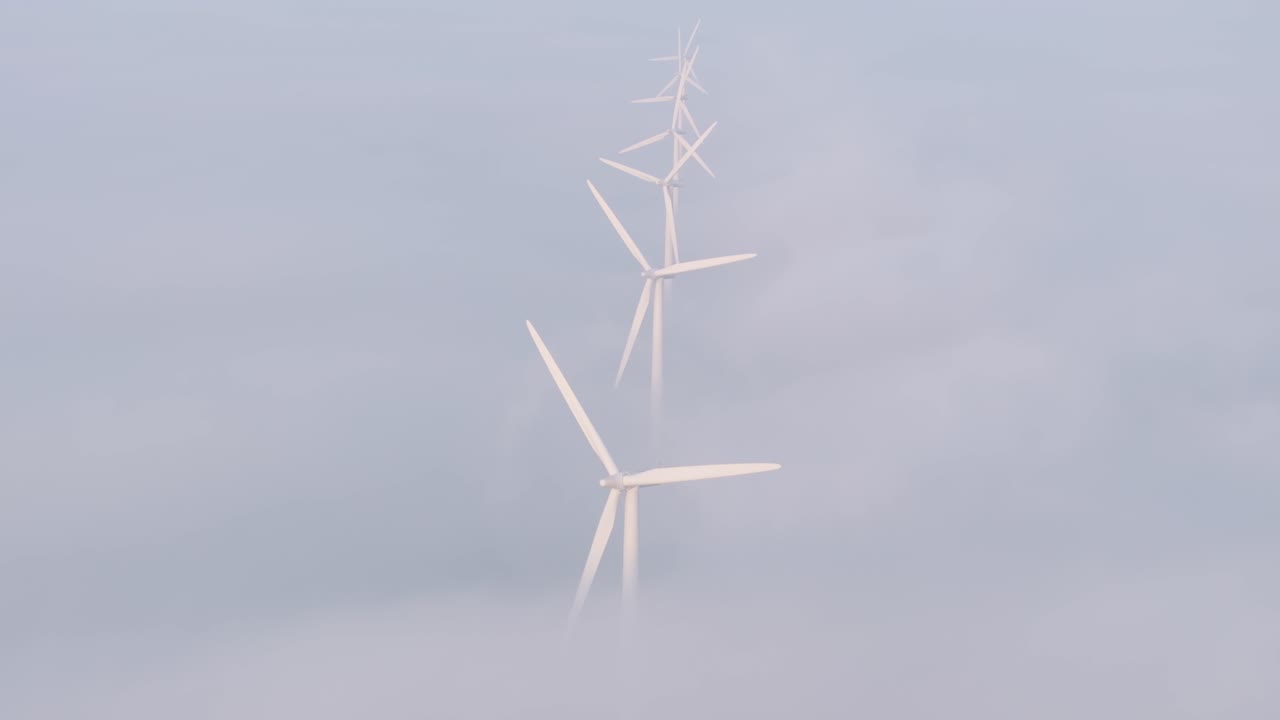 Luftaufnahme von Bolsward mit Windkraftanlage, Nebel, Sonnenaufgang, die eine friedliche ländliche Landschaft in den Niederlanden zeigt.