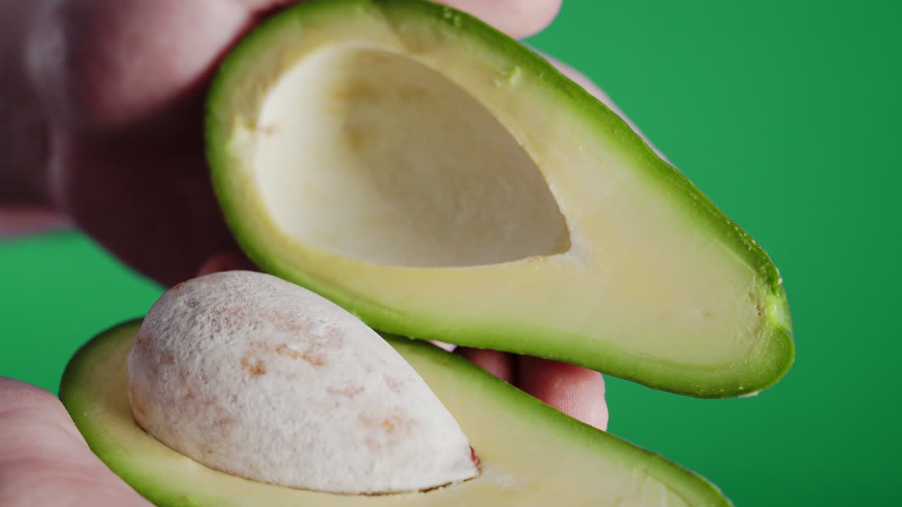 Apertura di avocado fresco tagliato a metà