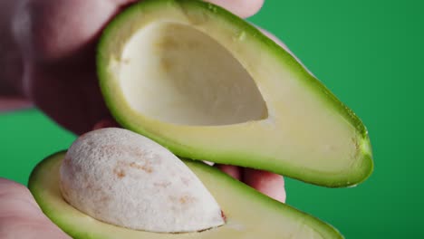 abriendo un aguacate recién cortado a la mitad.