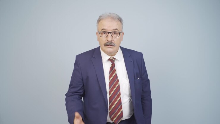 Businessman looking at camera in amazement.