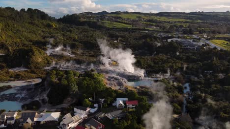 aerial pull back from pohutu geyser reveal historic living maori village and geothermal park in rotorua, new zealand