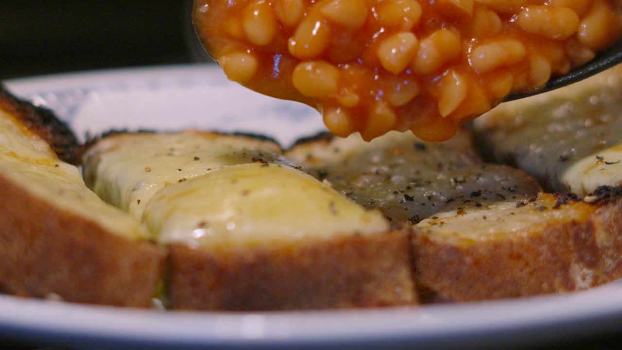 Melted Cheese on Homemade Bread Toast with Baked Beans Slowly Lowered on Top in Slow Motion. Lunch Food Footage 4K.