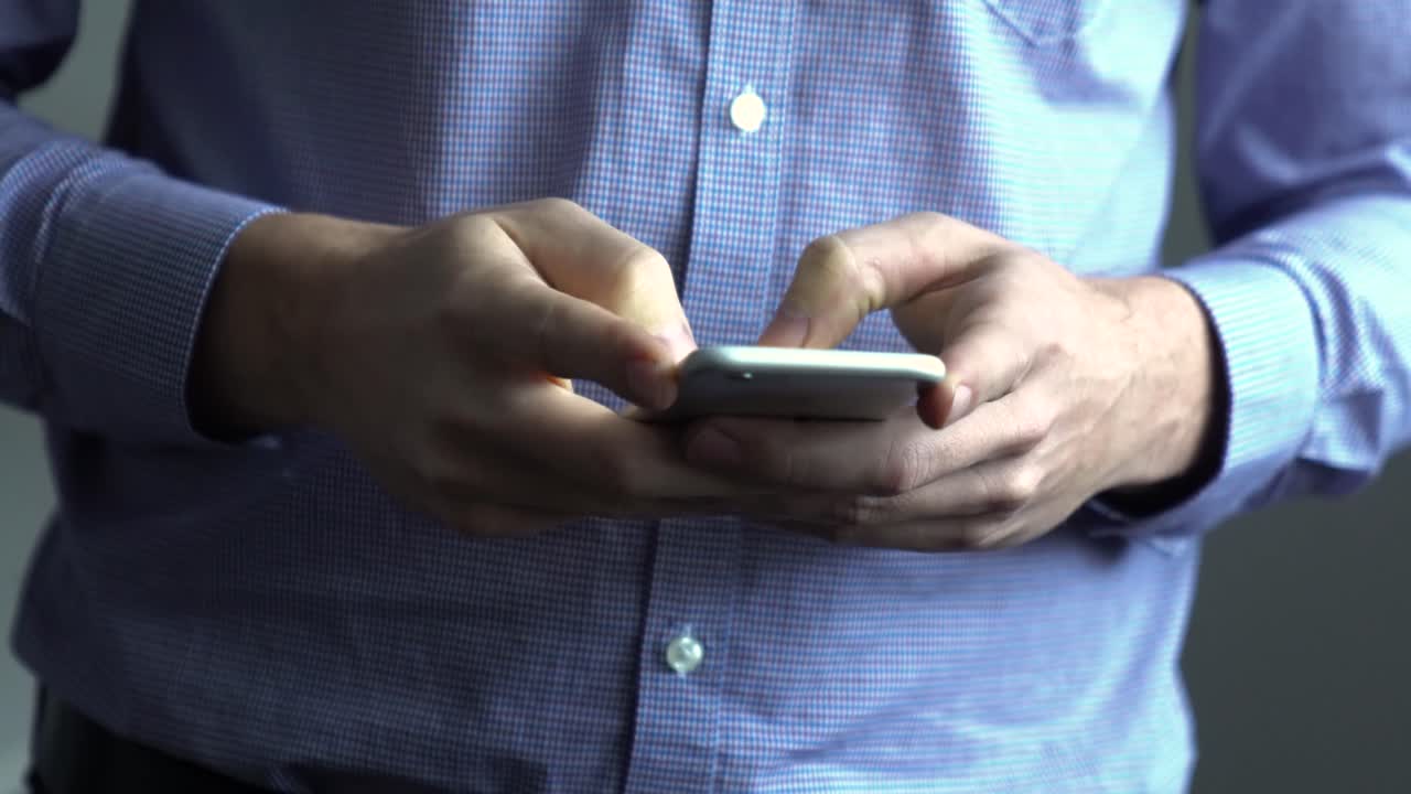 Man addicted to cellphone, typing on mobile phone sending messages