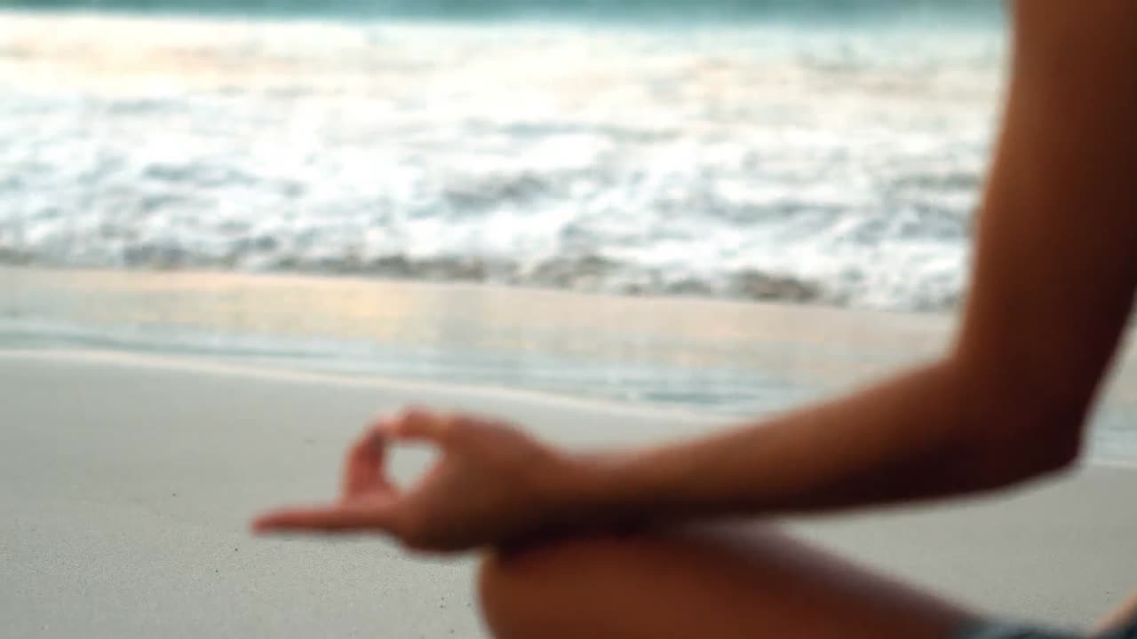 mujer realizando yoga en la playa