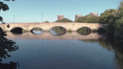 stone arch bridge over calm river