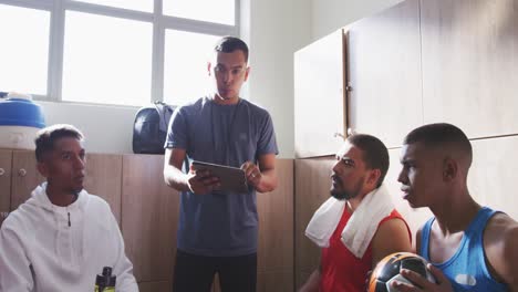 coach talking to soccer players in the locker room