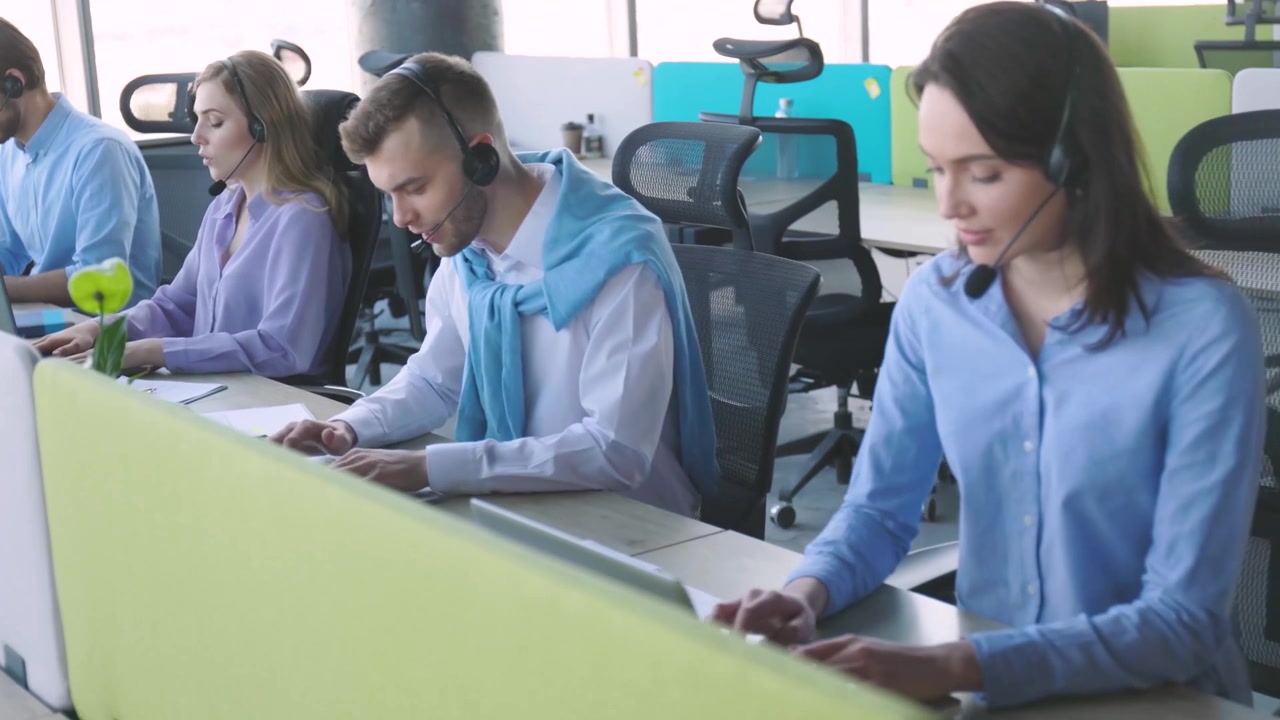 Equipo de atención al cliente trabajando en portátiles en una oficina moderna