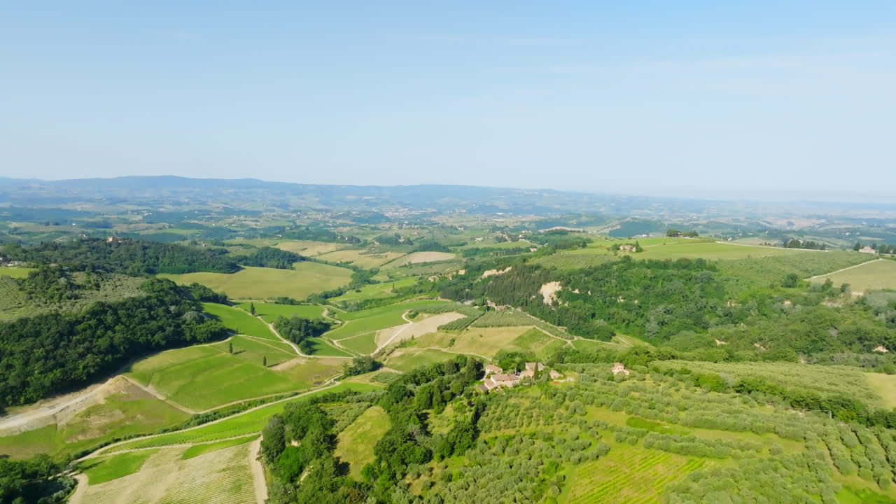 Aerial view rising over vineyards and nature of Tuscany, sunny day in Italy