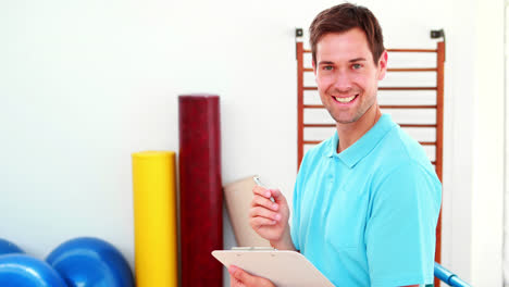 Smiling-physical-therapist-writing-on-clipboard