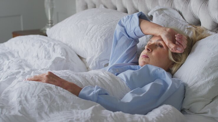 Menopausal Mature Woman Suffering With Insomnia In Bed At Home