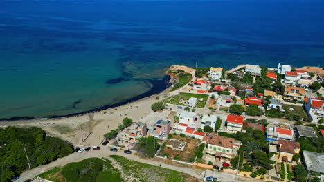 aerial view of greek coastal town with sandy beach,white buildings with red roofs