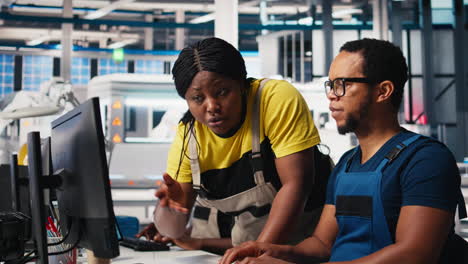 vertical video african american team programs robotic arms in solar panel facility