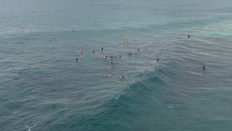 Surfers-gather-near-Ehukai-beach-in-Ohau,-Hawaii,-aerial-drone-view