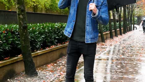 man holding umbrella and talking on mobile phone