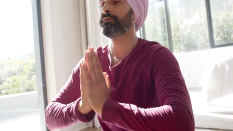 meditating at home, indian man in prayer pose, practicing mindfulness