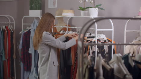 mujer atractiva sonriendo a la cámara mientras se prueba un nuevo vestido en la tienda. hermosa cliente femenina de pie frente al espejo en un camerino