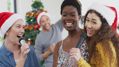 Happy-group-of-diverse-friends-singing-karaoke-at-christmas-party