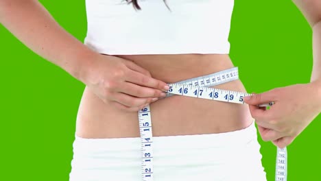 close up of a woman measuring her waist