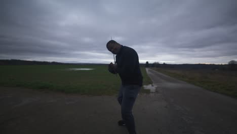 modern black swordsman warrior awaiting battle opponent in open field under grey sky, europe, 4k | muscular, intimidating, shadow, figure, blurry, dark clothes, powerful, taunt, slash, smiling